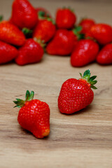 Fresh delicious selected strawberries on a brown wooden table
