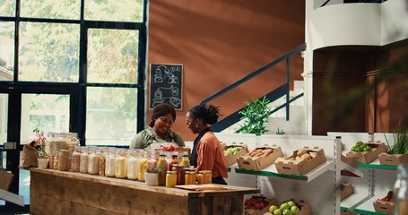 Supplier bringing fresh products to vendor at farmers market, holding crate of freshly harvested fruits and veggies. Merchant receiving merchandise from local farm, eco friendly. Handheld shot.