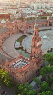 Flying over the Plaza de Espana at sunrise in Seville, Spain. Aerial view of the famous Spanish Square and Maria Luisa park in the morning in Seville, Andalusia region.