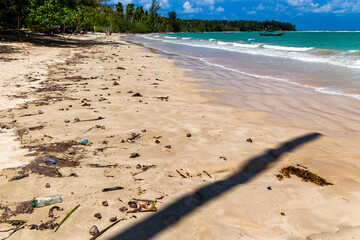 Plastic bottles and other pollution washed up onto a tropical beach by the tide  in asia