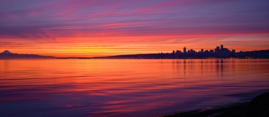 Colorful Seattle Sunrise Across Elliott Bay. Seen from West Seattle this modern city sparkles just before the sun rises above