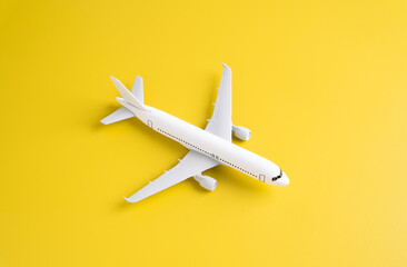 Passenger plane on a yellow background. Airplane figurine. Commercial flights