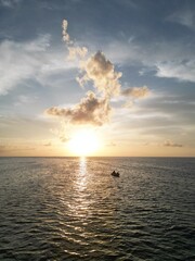 Beautiful sunset scene with the shilouette of a boat with two people. View from above with aereal view from a drone. Picture from san andres islands, Colombia.