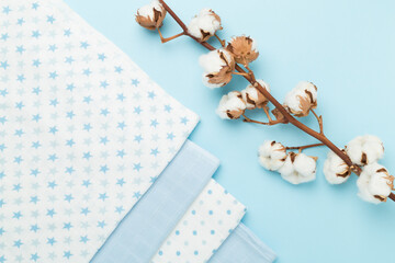 Cotton fabric with branch on color background, top view