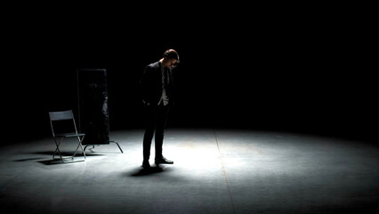 Man in suit alone on theater stage. Stock footage. Single attractive man in suit is playing on...