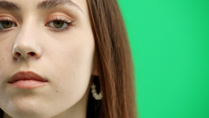 Fototapeta premium Woman's face, close-up, on a green background