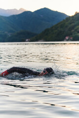 A professional triathlete trains with unwavering dedication for an upcoming competition at a lake,...