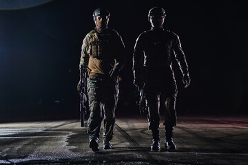 Two professional soldiers marching through the dark of night on a dangerous mission, epitomizing...