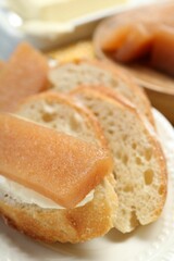 Delicious quince paste and bread on table, closeup