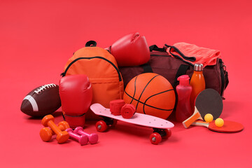 Many different sports equipment on red background