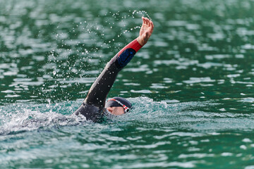 A professional triathlete trains with unwavering dedication for an upcoming competition at a lake,...