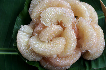 peeled pomelo on banana leaf