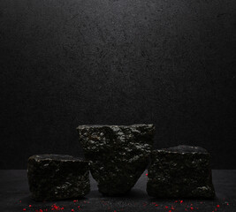 black stones with texture on a black background for the podium