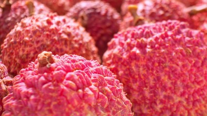 Dive into a vibrant world of tropical allure with a close-up of luscious lychee fruits. Their...