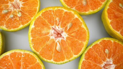 Halved green oranges display their succulent, vibrant flesh, promising a burst of tangy refreshment. Seeds peek from the center, nature's treasure. Orange fruit background.
