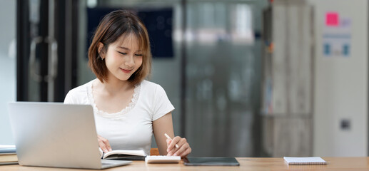 Young cute asian woman working from home, sitting at her desk home office.