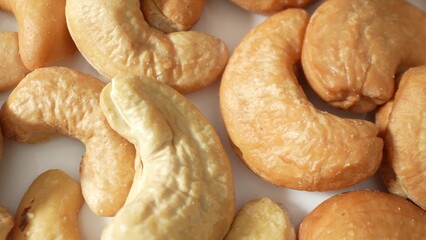 Behold the roasted cashew nuts, gleaming with a golden-brown sheen, their textured surface inviting a sensory journey. A delectable snack, a versatile ingredient, each nut a savory masterpiece.
