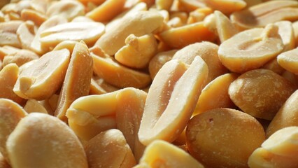 Roasted peanuts, each split, revealing a spectrum of golden hues. The rich texture and occasional...
