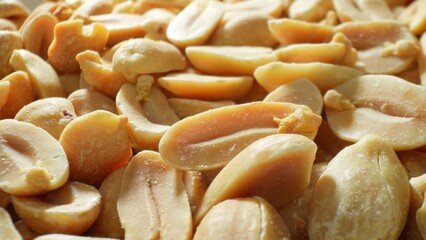 Roasted peanuts, split to reveal golden hues, dominate the scene. The rich texture and occasional...