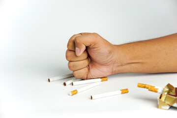 man's fist destroys cigarette isolated on white, smoking cessation concept, World No Tobacco Day