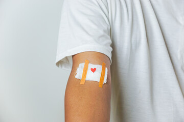 World Blood Donor Day. Blood donor with bandage after donating blood with white background. Copy...