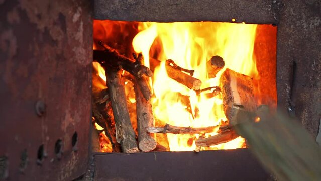Brightly burning dry firewood in steel stove closeup. Relaxing picture for evening contemplation in snowy winter weather creating home cozy ambiance