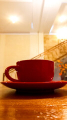 view of latte coffee in red cup isolated on wooden table background.
