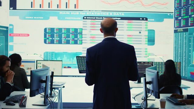 General director employing big data to help in solving tasks in control room, operating on huge screen to create a performance metrics analysis. Manager ensuring organizational efficiency. Camera B.