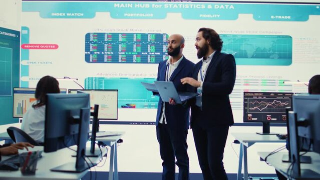 Team of investors analyzing profit amount and making decisions to fund another business project, examine big data on a huge display. Associates verifying efficiency and budget. Camera B.