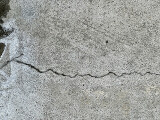 a photography of a black and white photo of a crack in concrete.