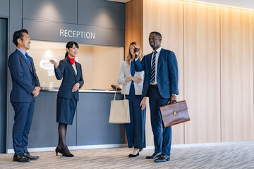 Employees at the reception guiding multinational visitors