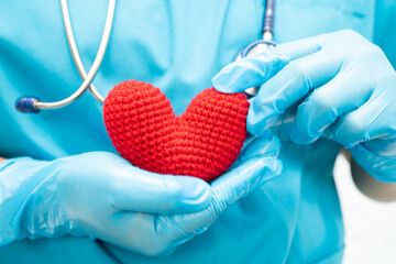 Doctor holding a red heart in hospital ward, healthy strong medical concept.