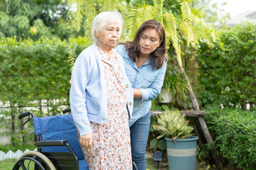 Caregiver help and care Asian senior woman patient sitting on wheelchair at nursing hospital ward, healthy strong medical.