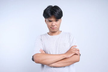 Potrait Of Serious Young Asian Guy Crossed Hands And Looking At Camera Isolated On White Background