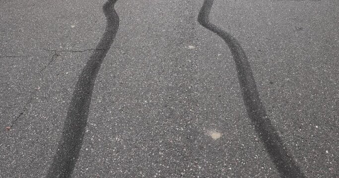 tire tracks during dangerous driving on the road , wheel streaks from sudden braking and drifting on an asphalt road