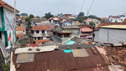 a view of a slum city from above in Asia with houses roof, poor environmental sanitation, densely...