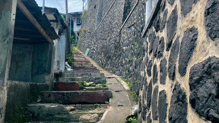 a narrow alleyway with a stone stairs in densely populated area in south east Asia slums city area