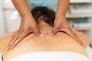 Masseur pressuring pain points of the back of a woman