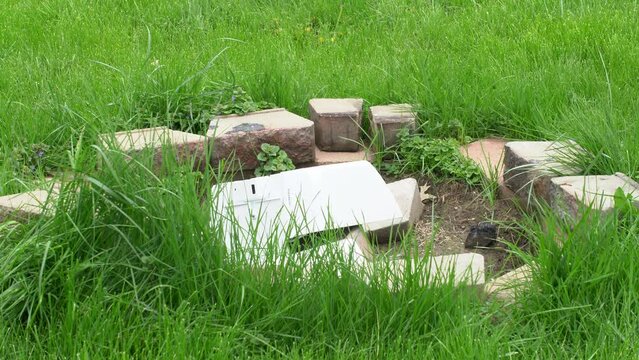 Thrown office printer copier shattered broken into pieces in circle of bricks conceptual rage mood