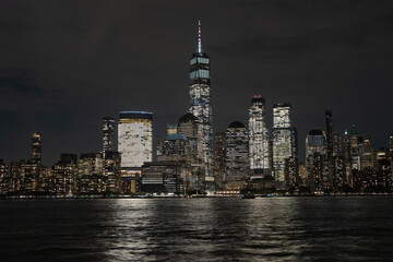 Obraz premium Night in The NYC city, USA, United States. Night day with iconic buildings. New York City NYC Manhattan Downtown Skyline, viewed from Jersey City, USA.