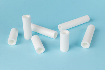 White Ceramic Tubes on Light Blue Background - Minimalist Industrial Elements