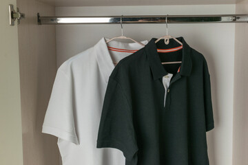 Wardrobe with Black and White Polo Shirts Hanging on Wooden Hangers