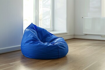 Blue bean bag in a bright minimalist living space with wood floor and white walls