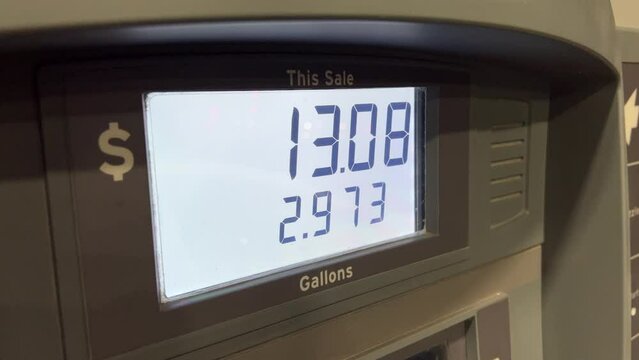 Sale at gas station pump as gallons are pumped into tank
