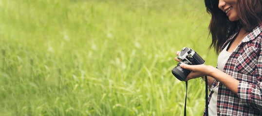 Banner Asian Women with vintage film camera take a photo. Panorama female photographer look at...
