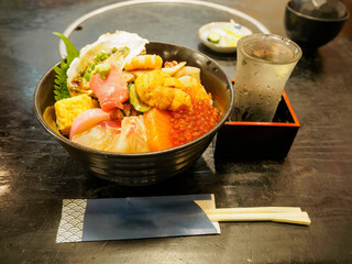 豪華な海鮮丼と冷酒。
本マグロの大トロ、ウニ、イクラ、マダイ、生牡蠣等が山盛り。
日本国東京都大田区、東京港野鳥公園にて。
2022年夏撮影。

大田市場内にあるお寿司屋さんでランチを食す。
Gorgeous Kaisen-don and cold sake.
A bowl of rice topped with a bowl of seafood and chilled sake. includ