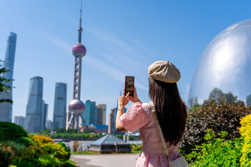 Young female tourist traveling and taking a photo at Shanghai, China