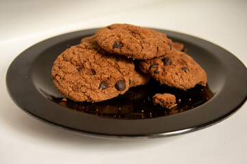 sweet chocolate biscuits on a black plate on a white background