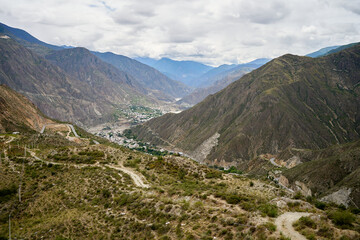 Town in a valley of mountains with cursive road