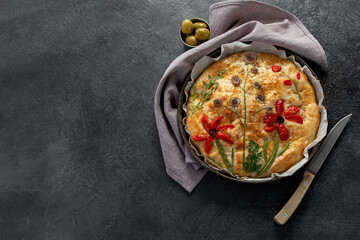 Homemade artistic focaccia bread using vegetables pieces for the picture. Food trend.